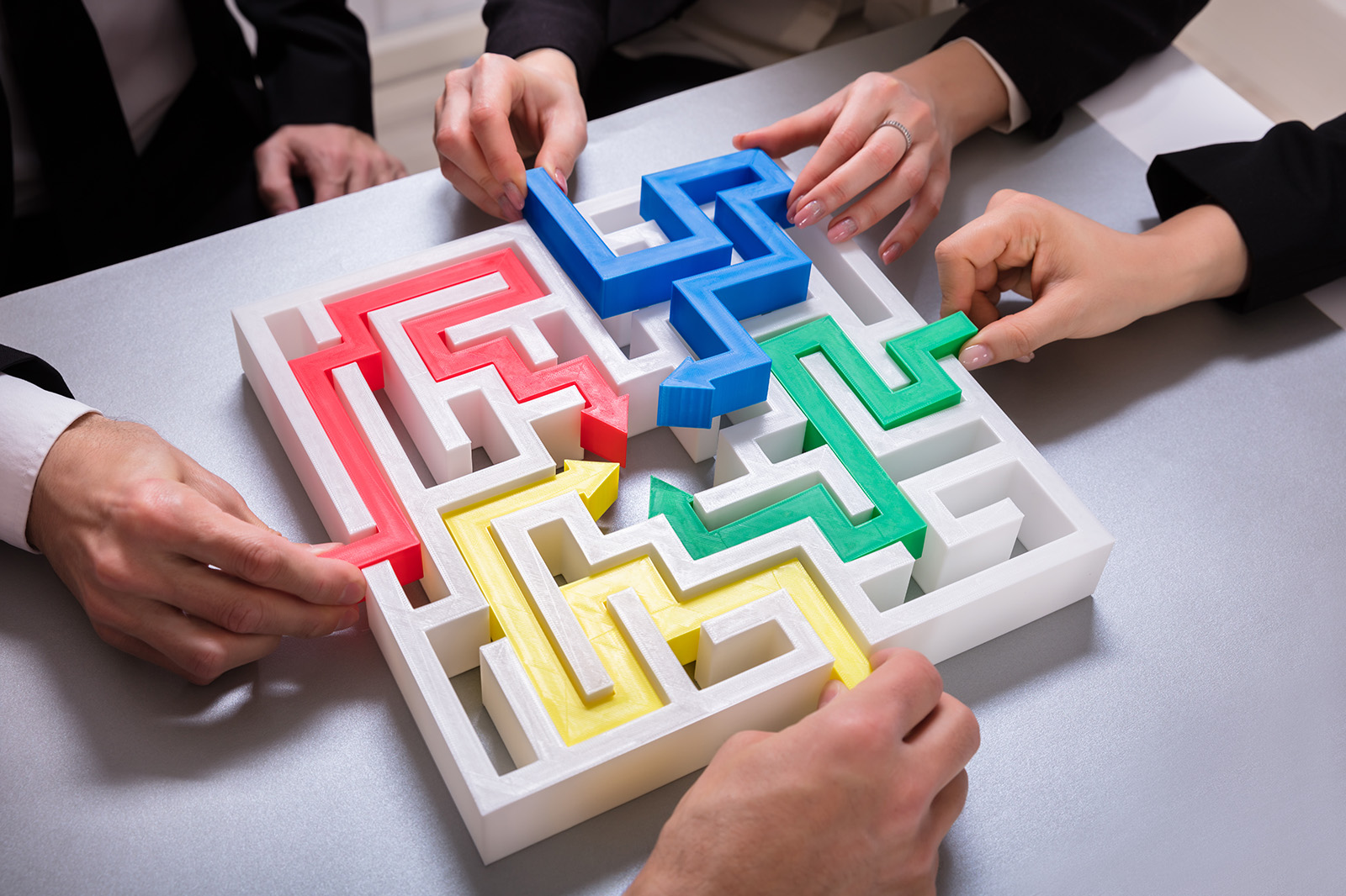 four people each solving a maze in their own way
