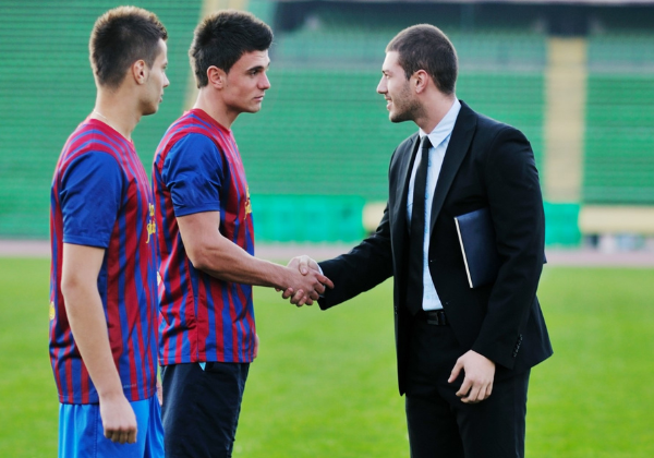 Soccer players shaking hands with businessman