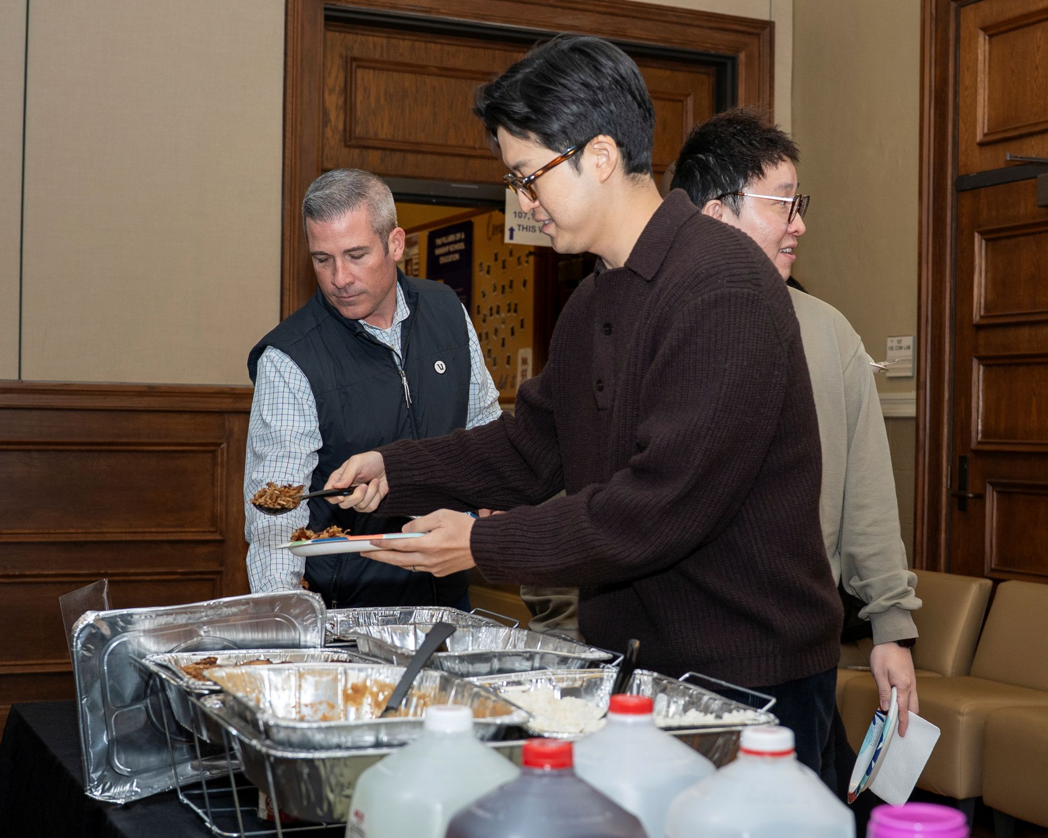 A professor getting jambalaya at an event for prospective graduate students